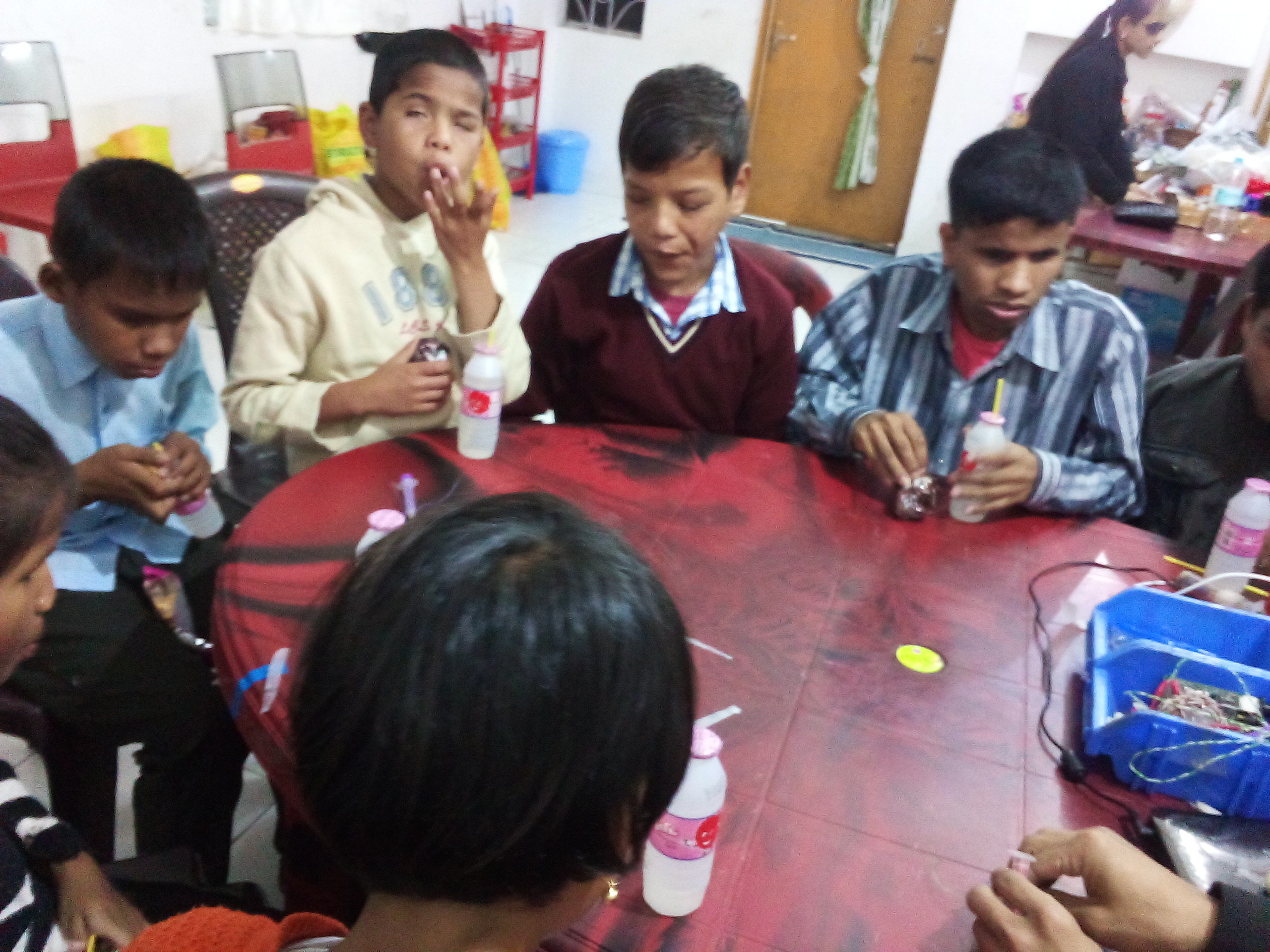 children sitting around a table  and having snacks - 2