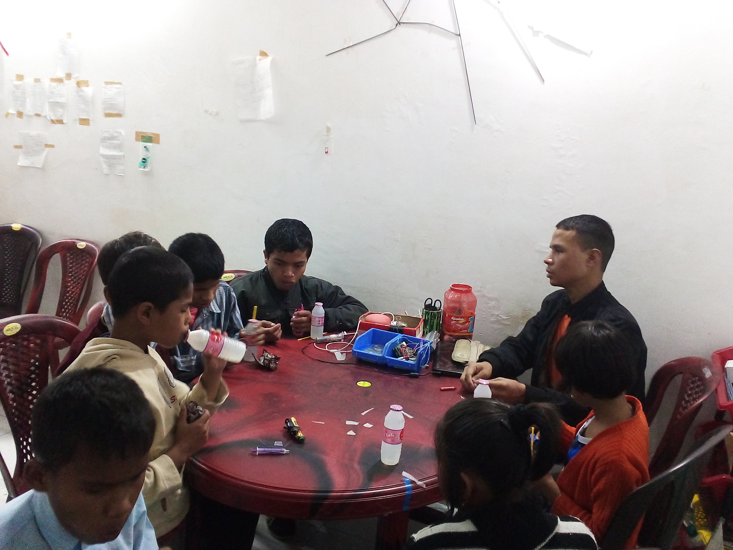Photo: children sitting around a table  and having snacks - 3